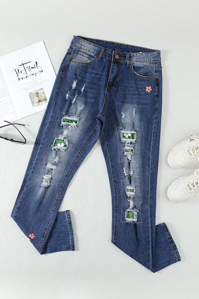 a pair of ripped jeans with a book and sunglasses
