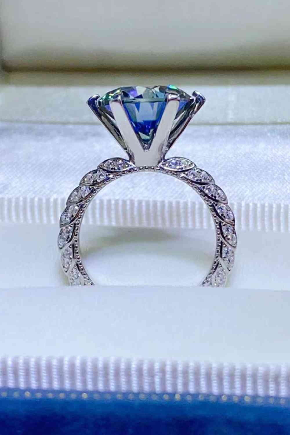 a diamond ring with a blue center surrounded by diamonds