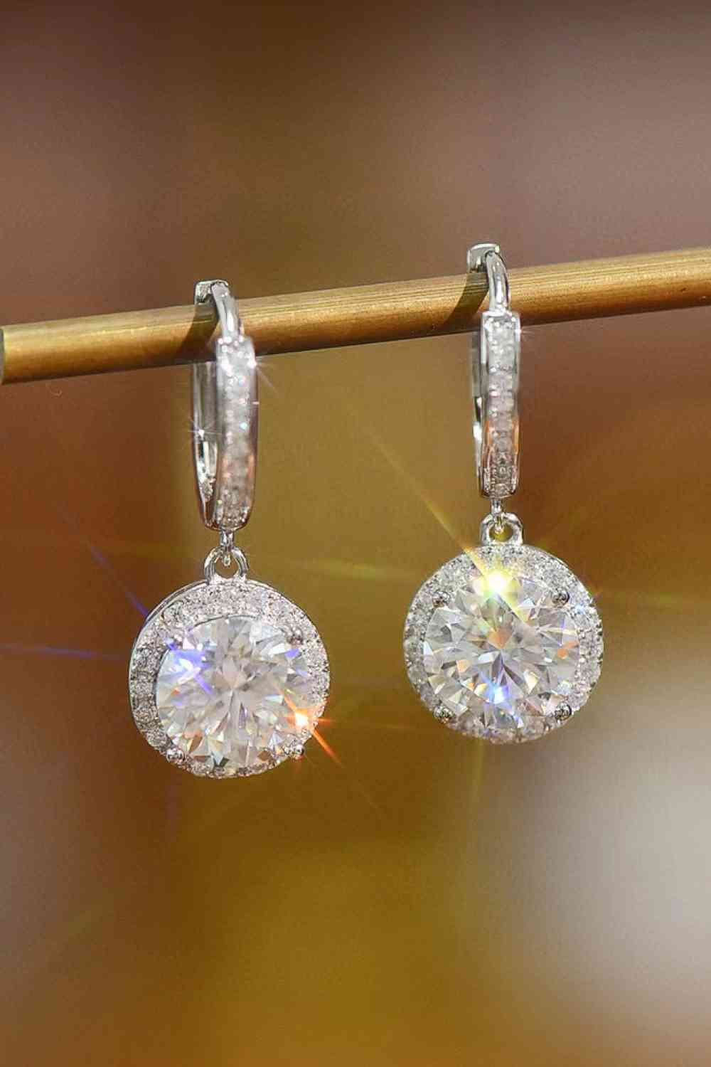 a pair of diamond earrings hanging from a hook