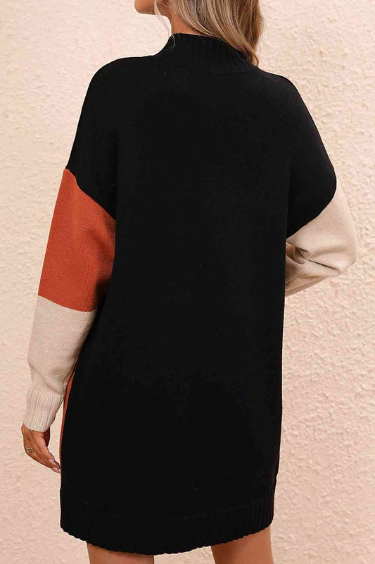a woman wearing a black and orange sweater dress