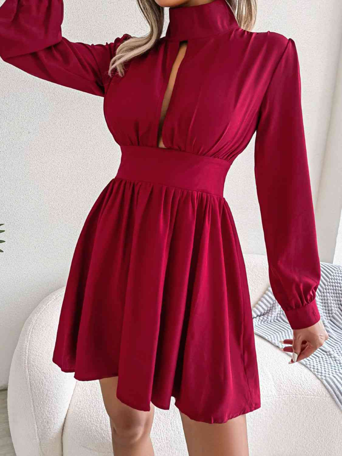 a woman wearing a red dress with a cut out neckline