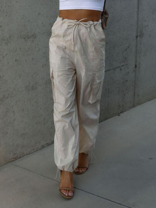 a woman in a white top and tan pants