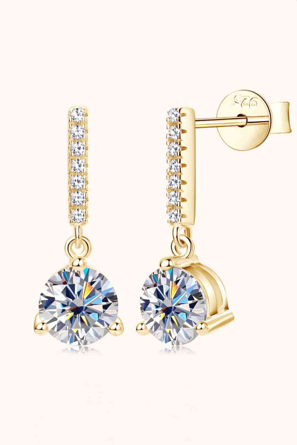a pair of gold tone earrings with clear crystal stones