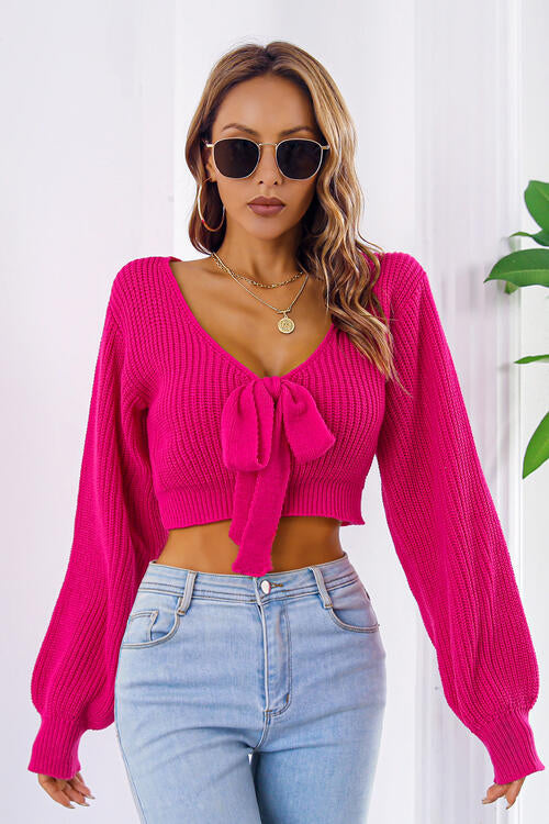 a woman wearing a pink sweater and jeans