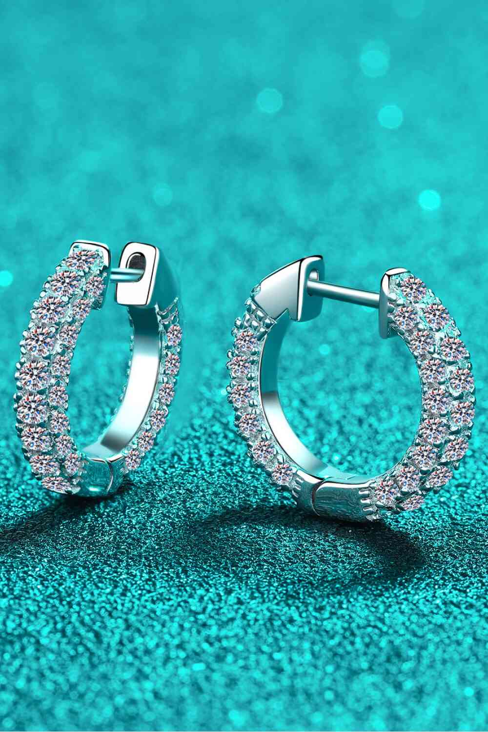 a pair of diamond hoop earrings on a blue background