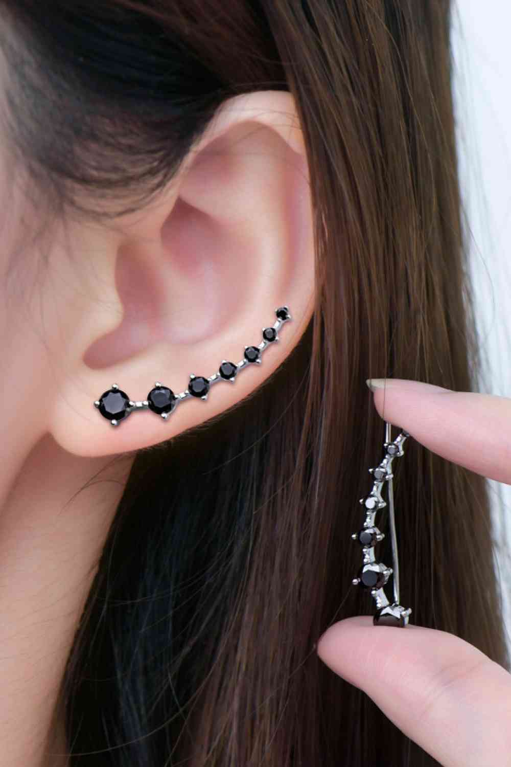 a woman wearing a black diamond ear cuff