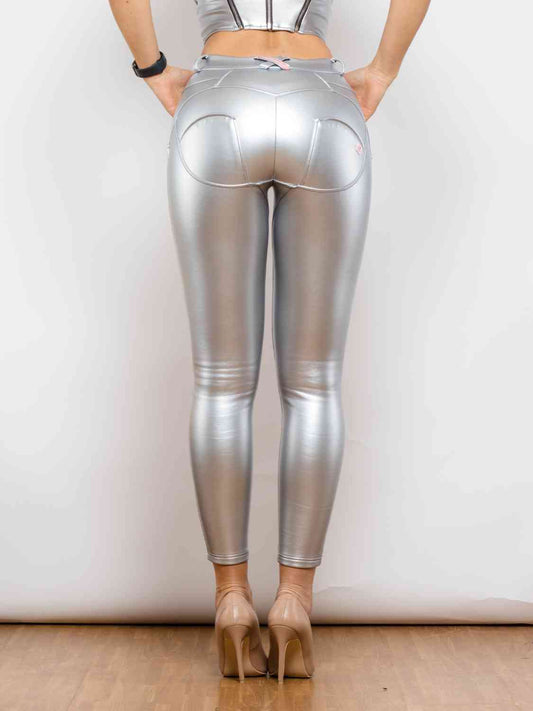 a woman in shiny silver pants and heels