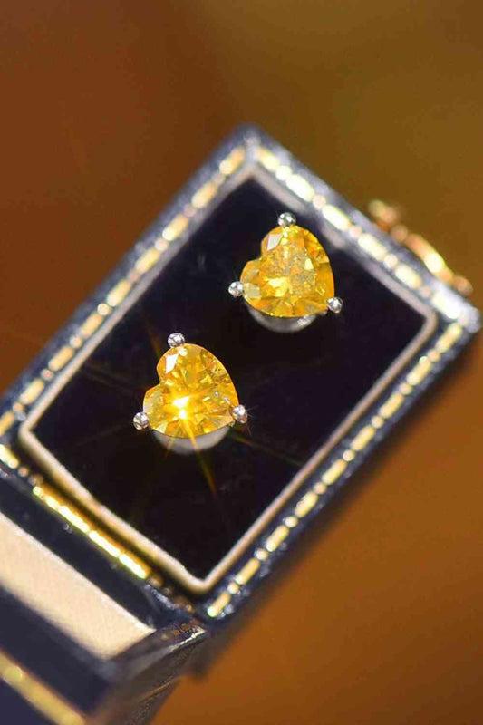 a pair of yellow diamond earrings sitting on top of a box