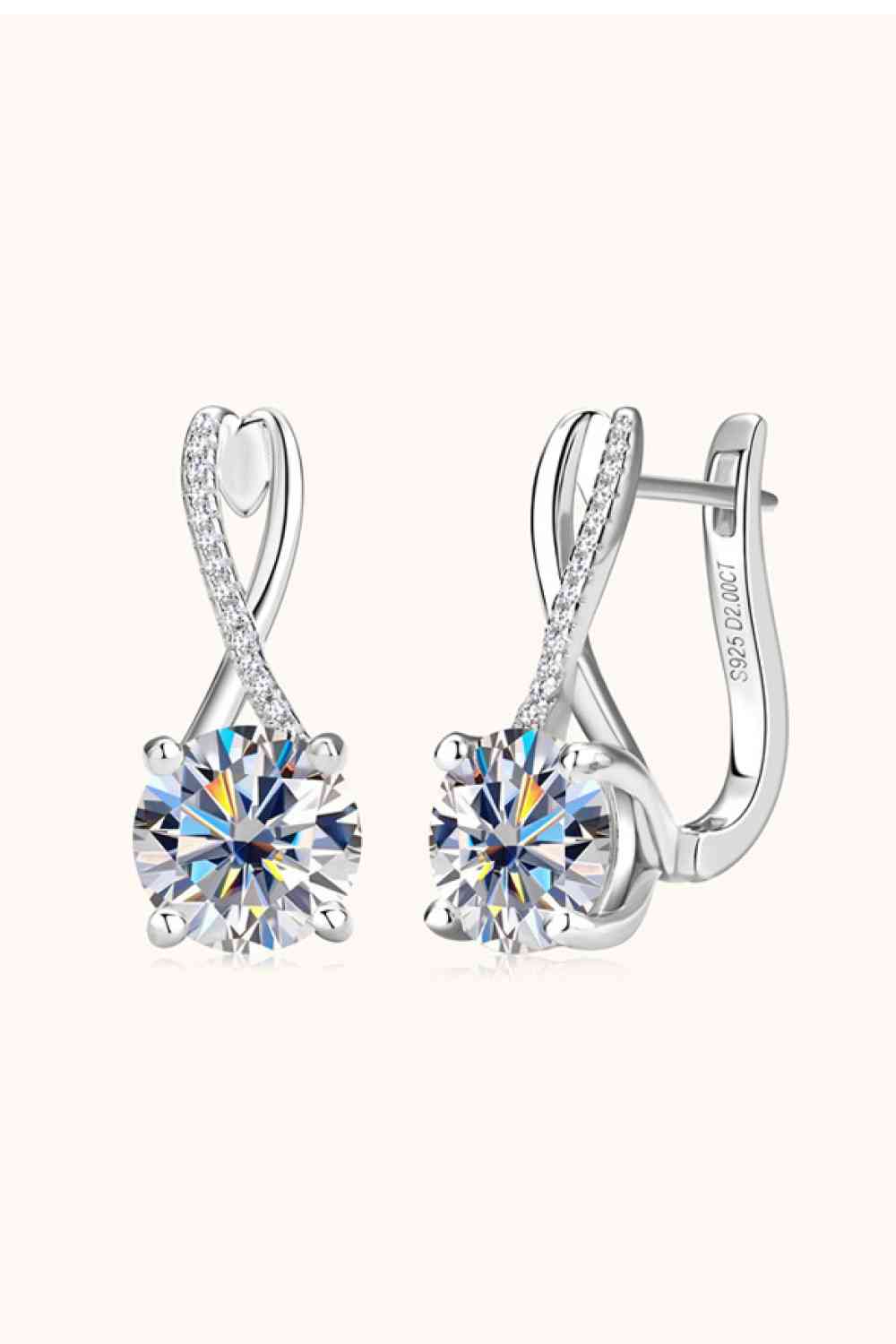 a pair of white gold earrings with a crystal stone