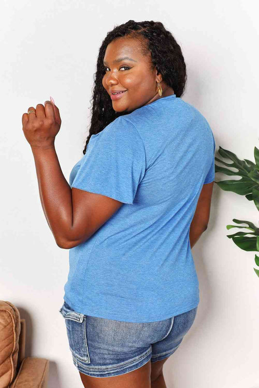 a woman in a blue shirt and denim shorts