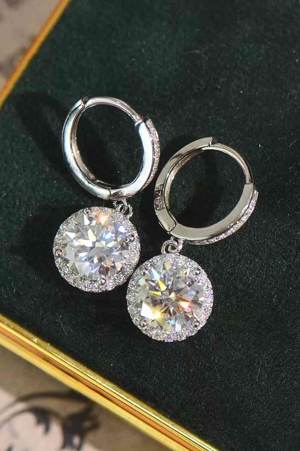 a pair of earrings on a black velvet surface