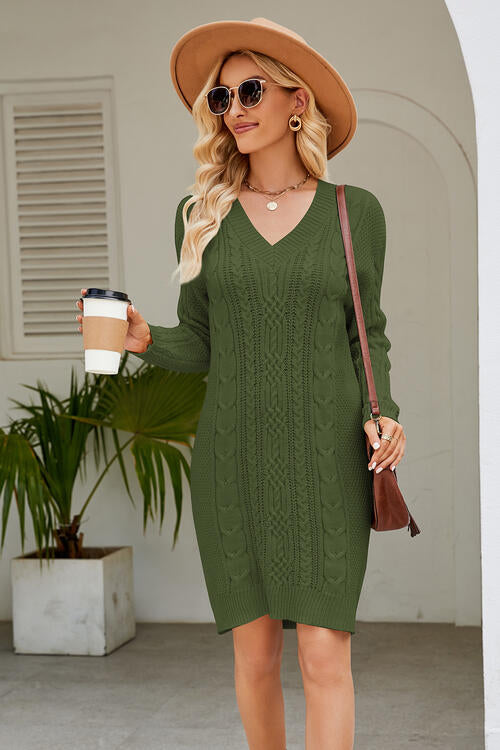 a woman in a green sweater dress holding a cup of coffee