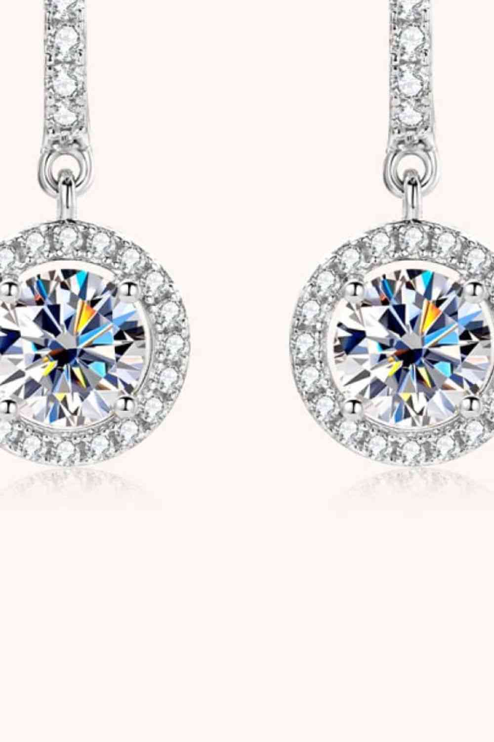 a pair of earrings with a round cut diamond