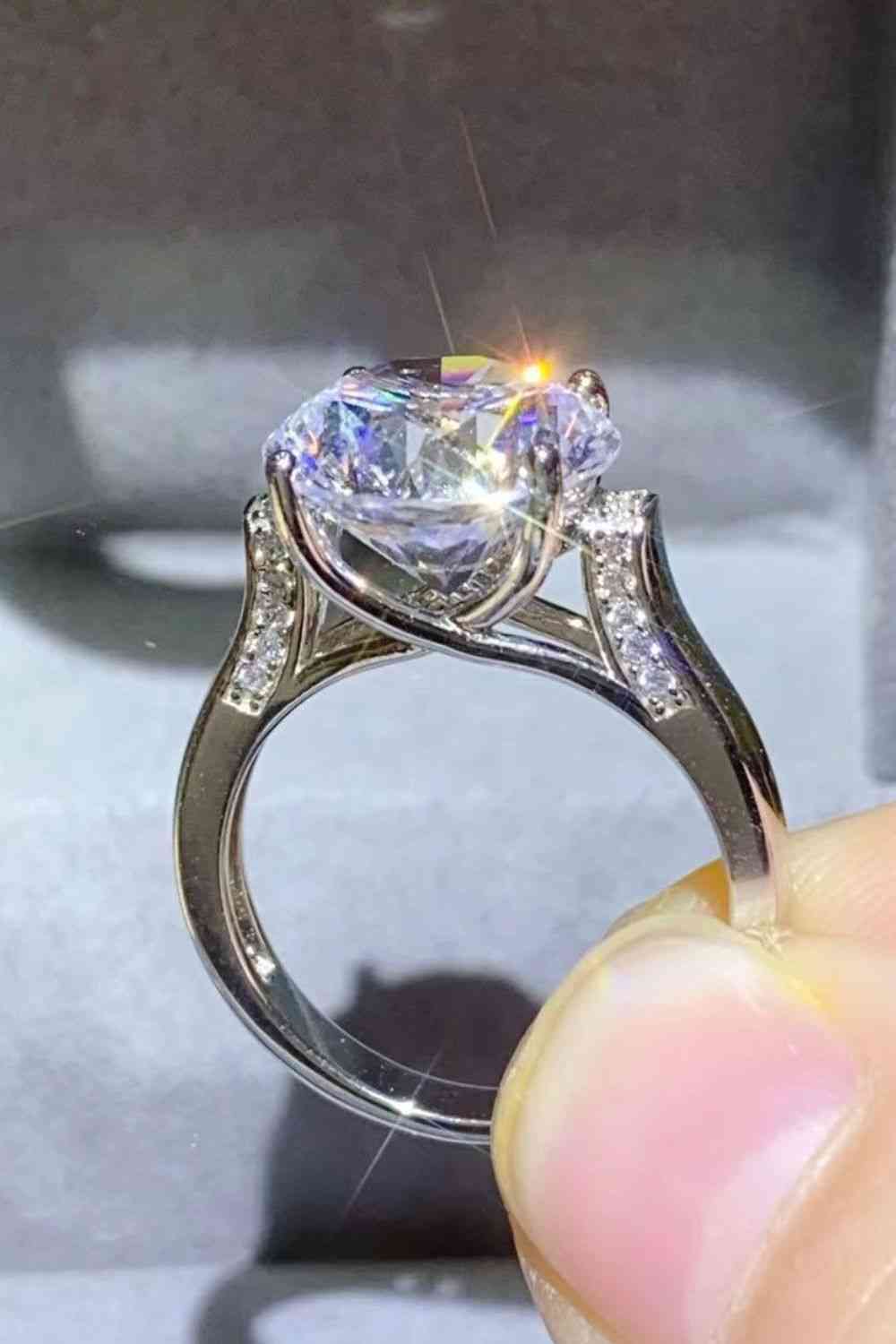 a person holding a diamond ring in their hand