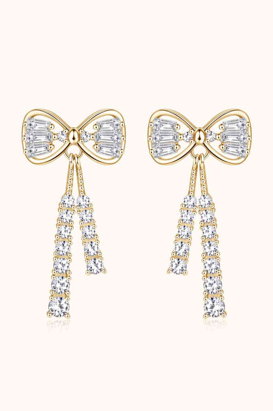 a pair of earrings with bows and crystals