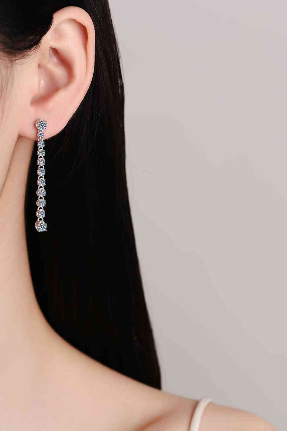 a woman wearing a pair of diamond earrings