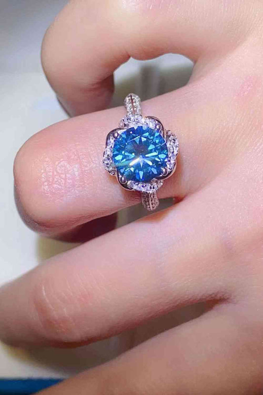 a woman's hand with a blue ring on it