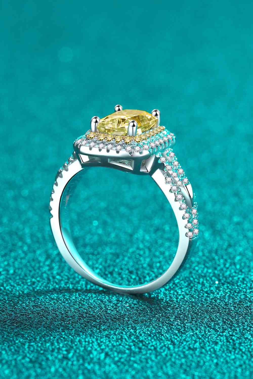a fancy yellow diamond ring on a blue background
