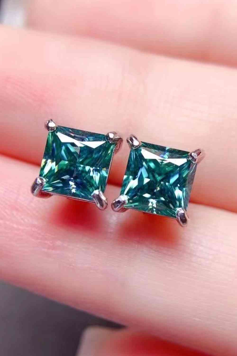a pair of square cut green diamond earrings