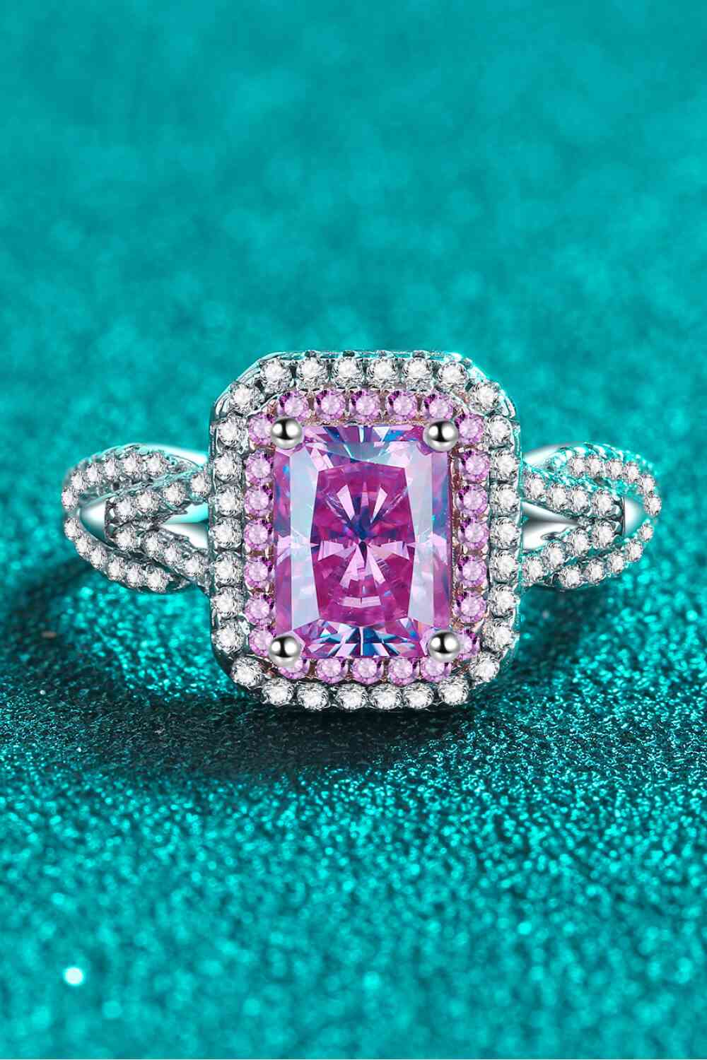 a fancy ring with a pink stone surrounded by diamonds