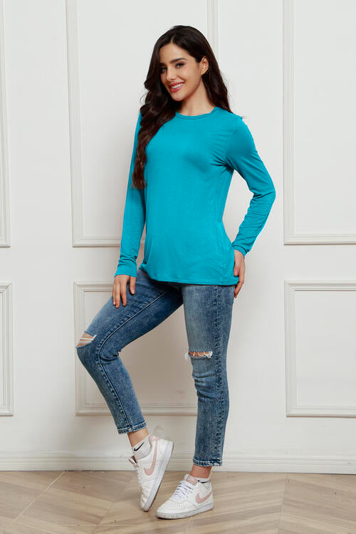 a woman in a blue shirt and ripped jeans