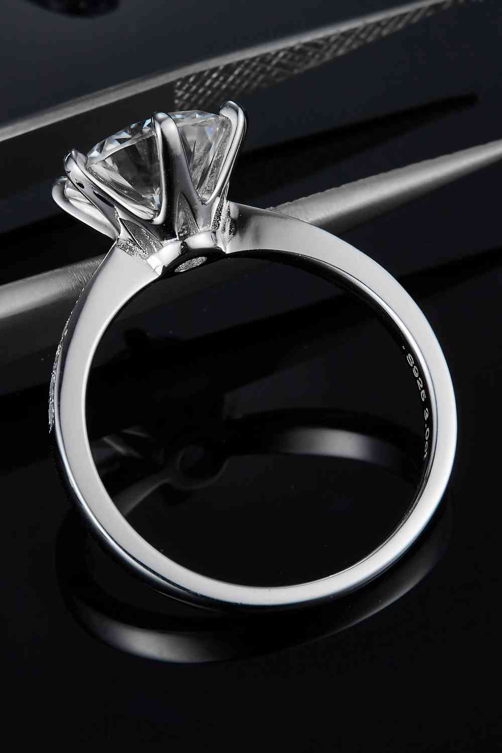 a close up of a diamond ring on a black surface