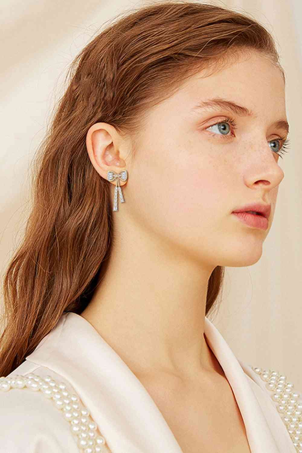 a woman wearing a white shirt and pearl earrings