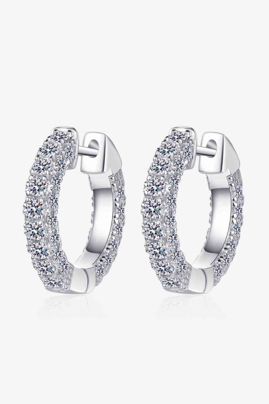 a pair of silvertone hoop earrings with clear stones