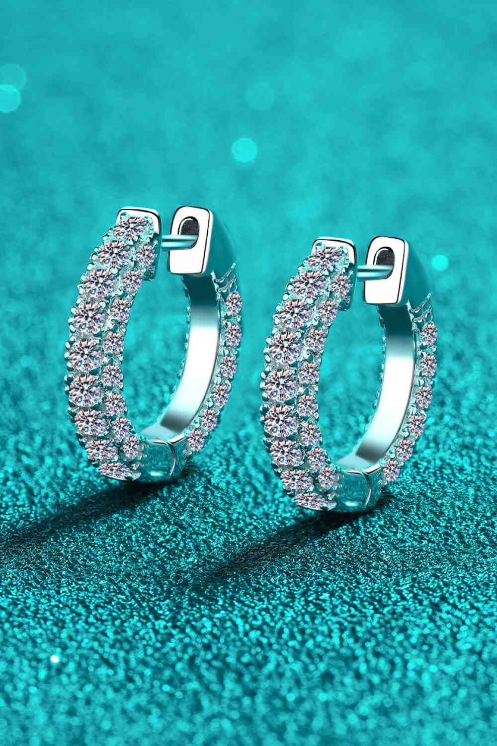a pair of silver hoop earrings on a blue background