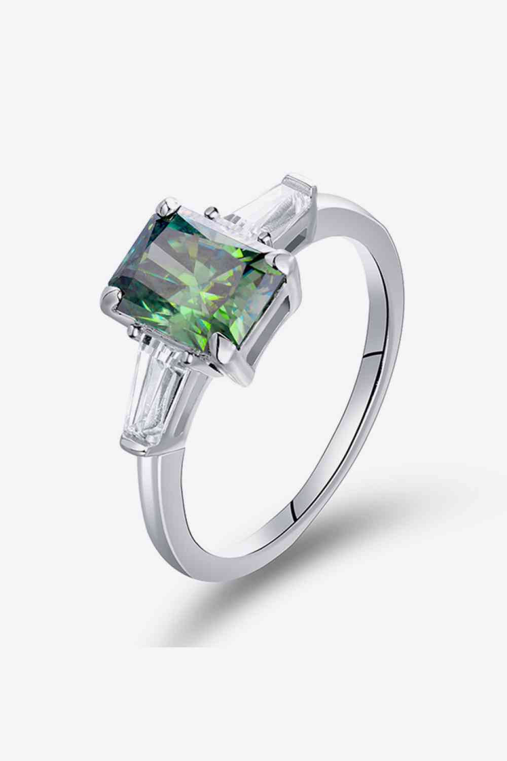 a white gold ring with a green diamond