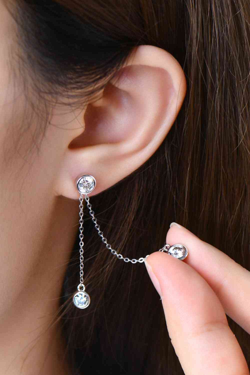 a woman wearing a silver chain earring