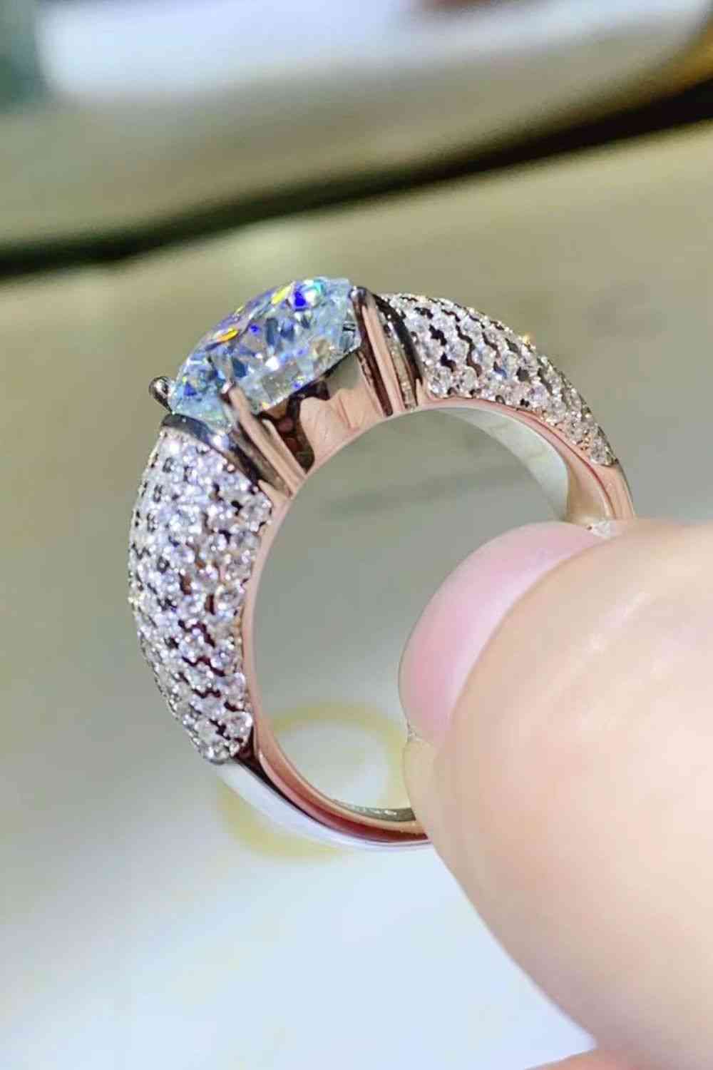 a person is holding a ring with diamonds on it