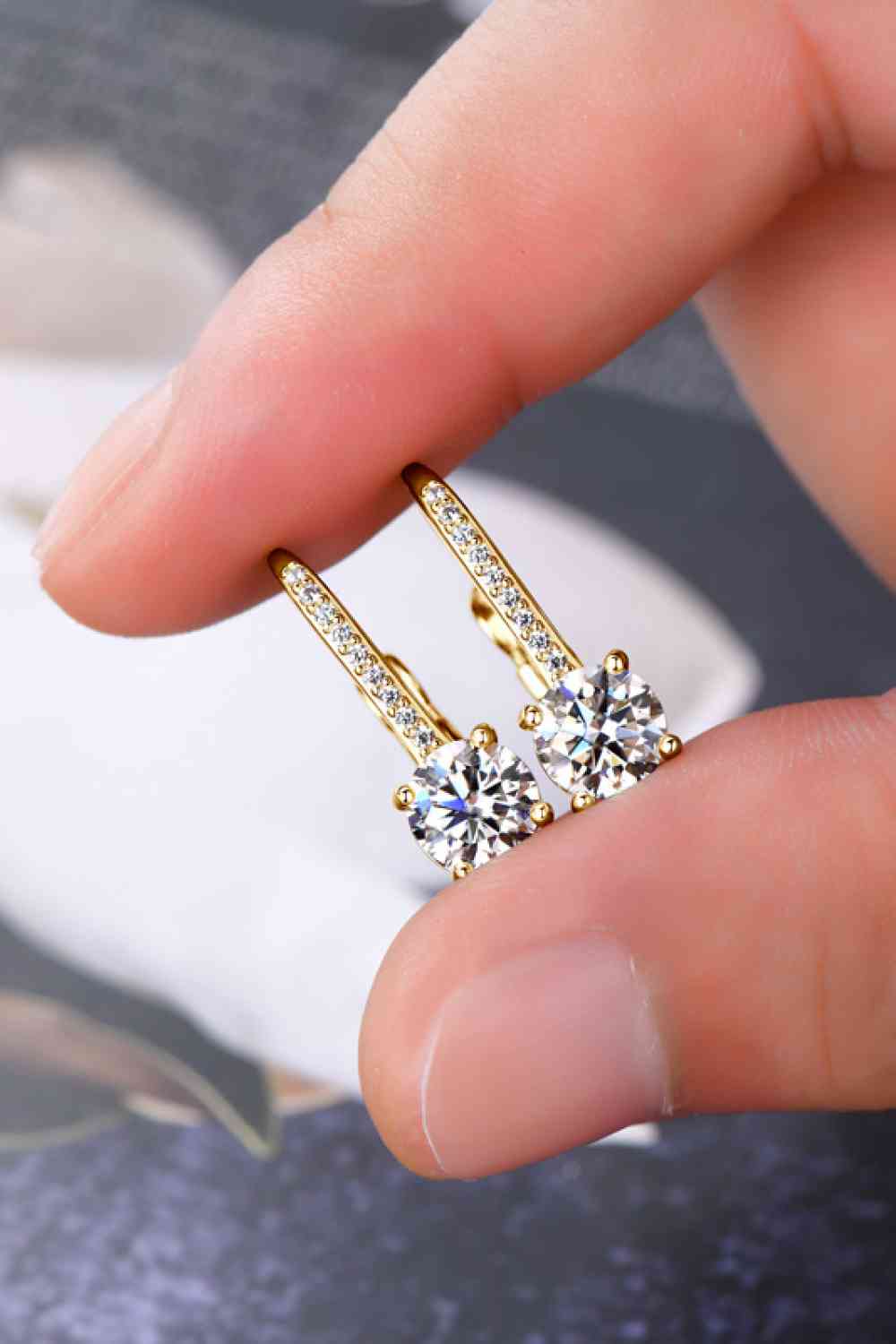 a person holding a pair of earrings in their hand