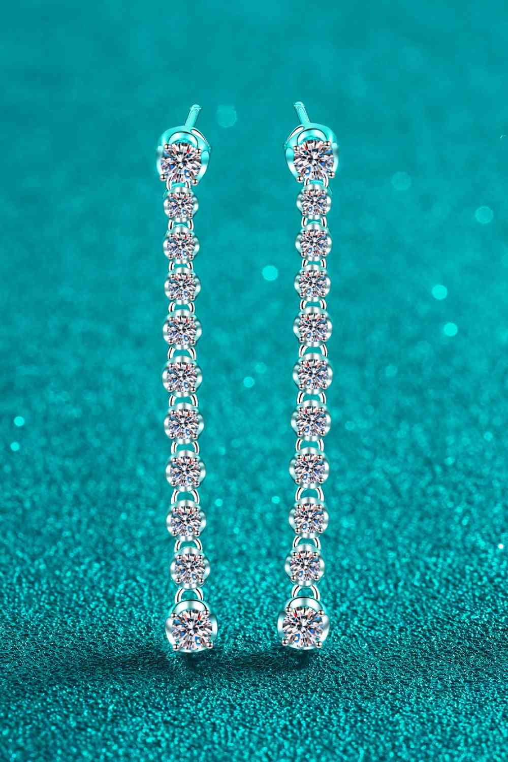 a pair of diamond earrings on a blue background