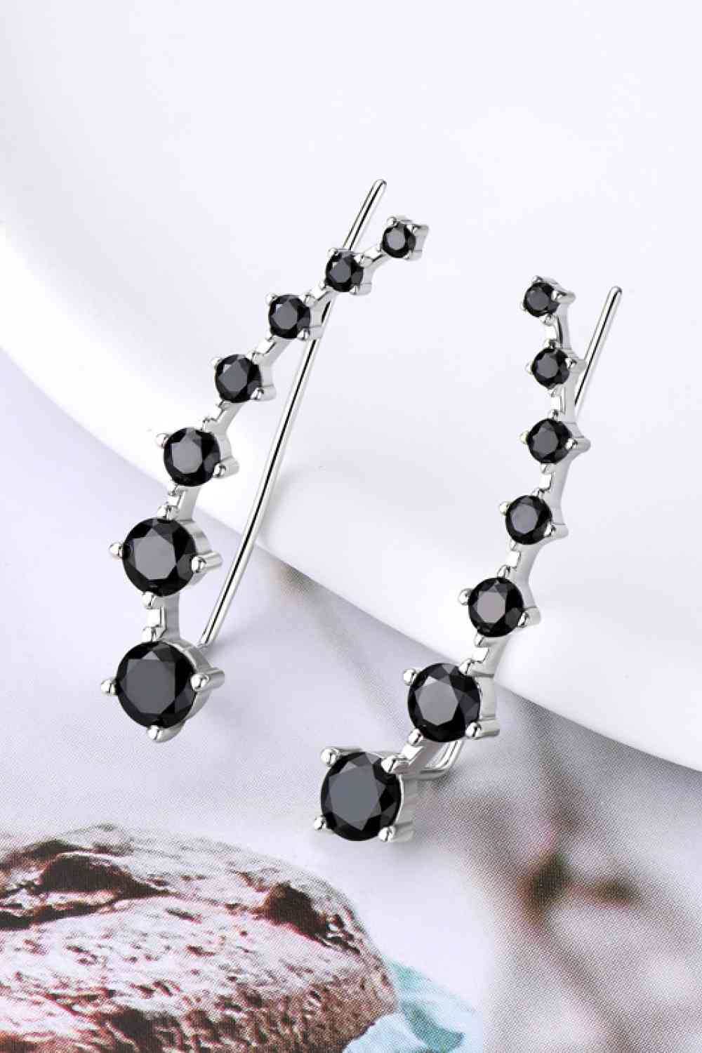 a pair of earrings with black stones