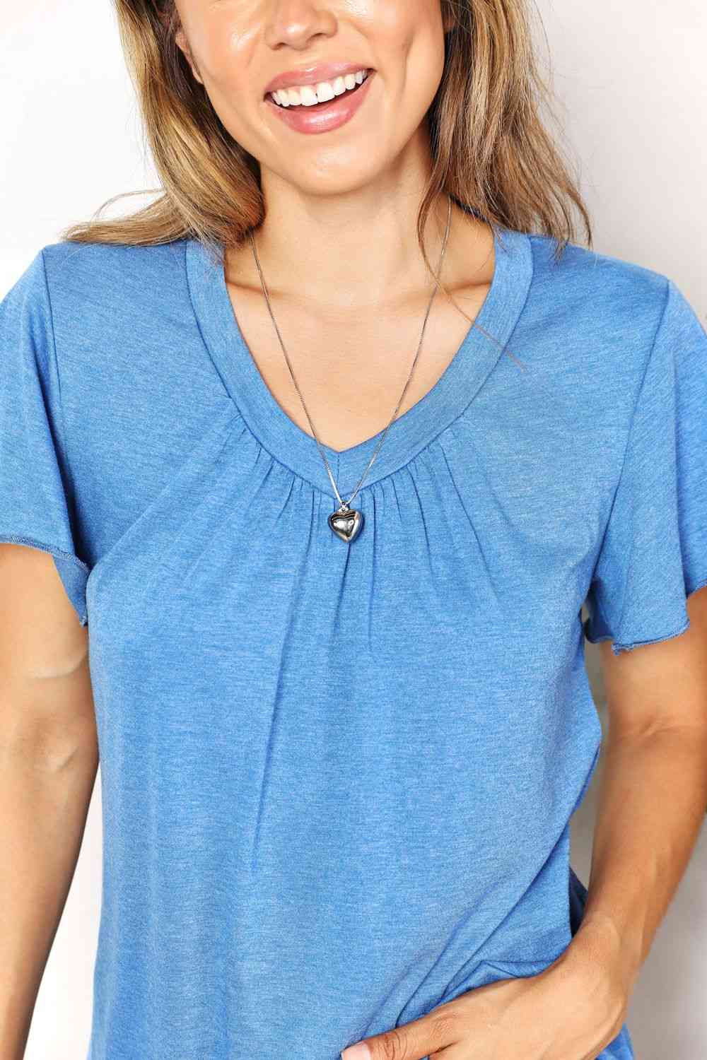 a woman wearing a blue shirt and a necklace