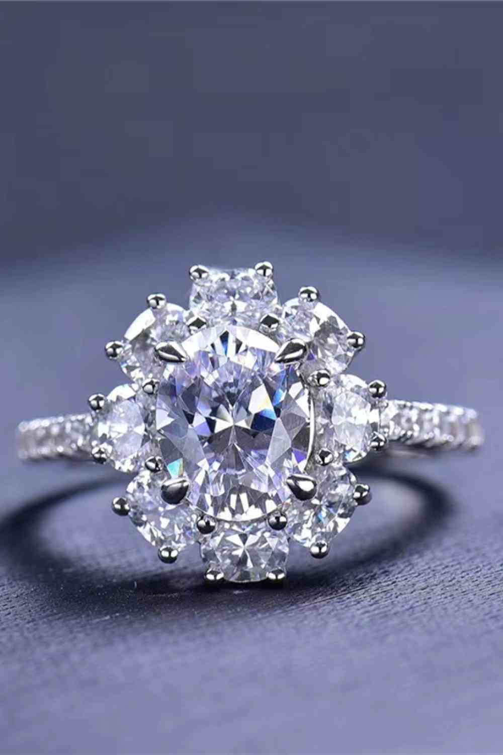 a diamond ring with a center stone surrounded by smaller diamonds