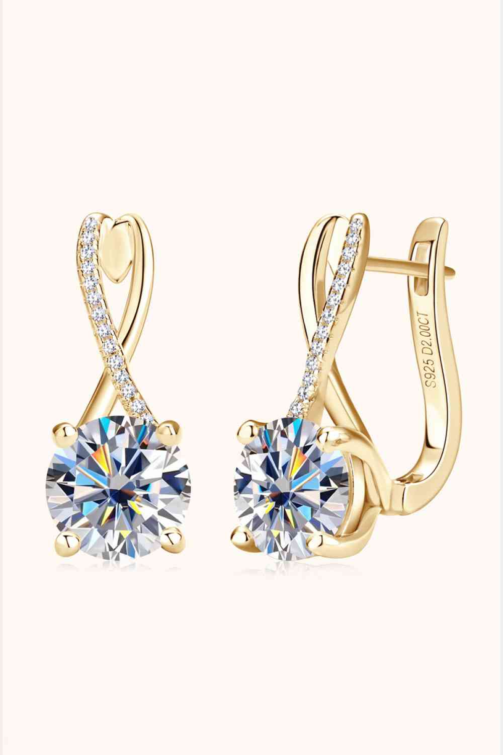 a pair of gold tone earrings with a crystal center