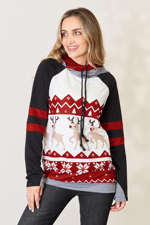 a woman wearing a red, white and black sweater with deer on it
