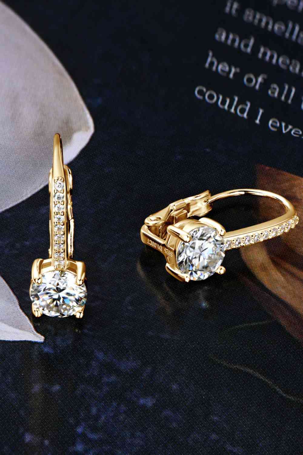 a pair of diamond earrings on a table