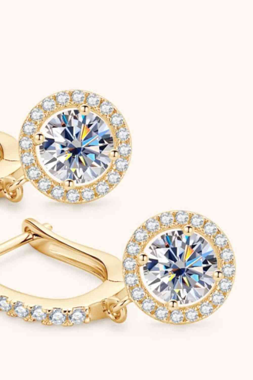 a pair of yellow gold earrings with a white diamond