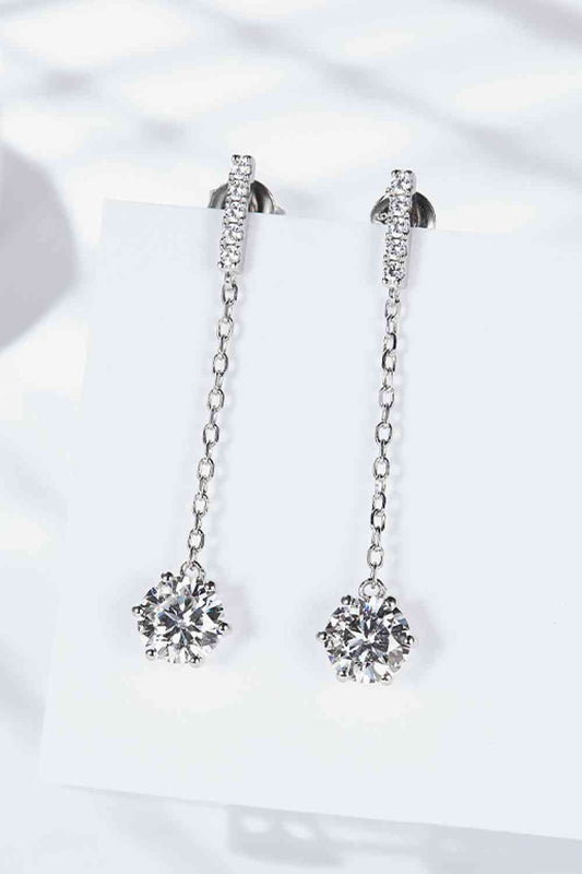 a pair of diamond earrings on a card