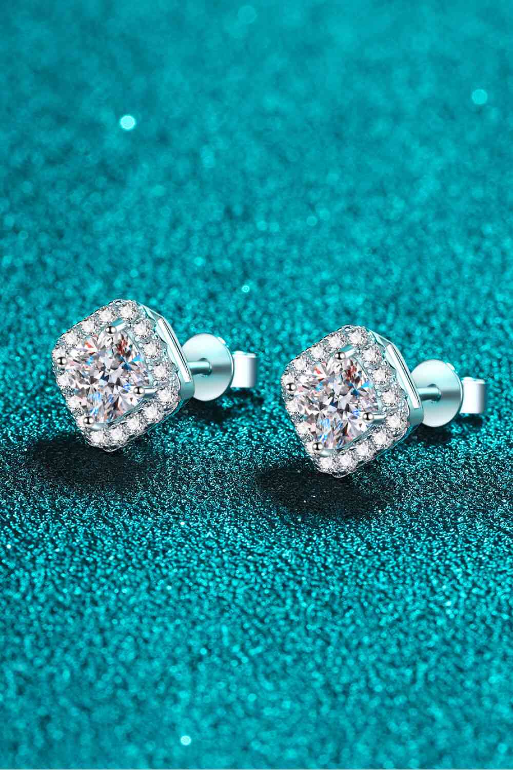 a pair of diamond earrings on a blue background