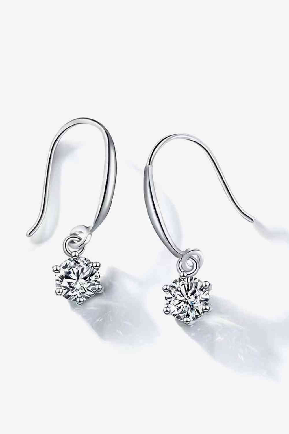 a pair of diamond earrings on a white background