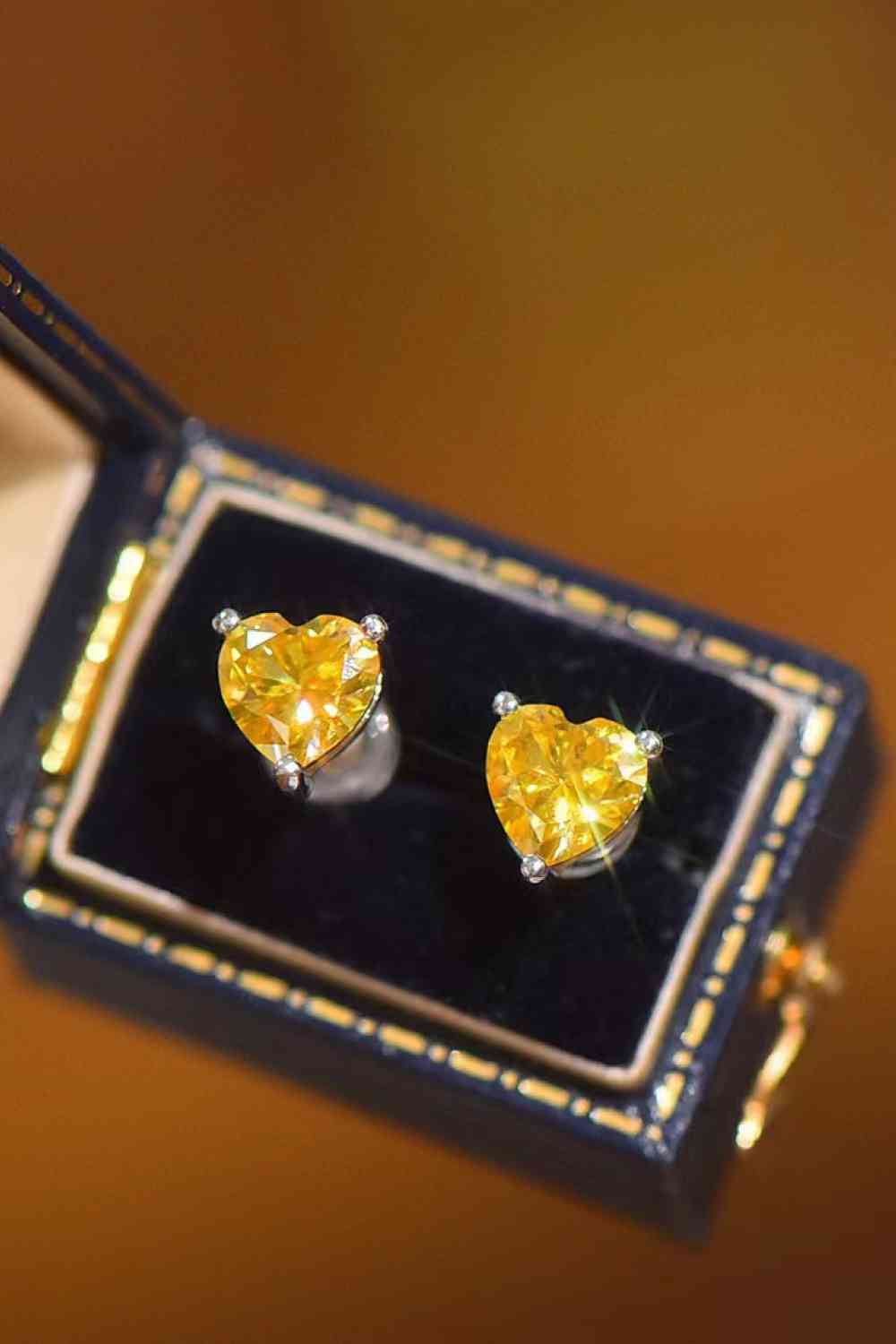 a pair of heart shaped yellow diamond earrings