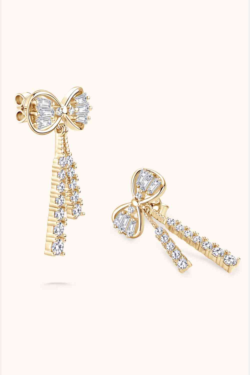 a pair of earrings with a bow and a key