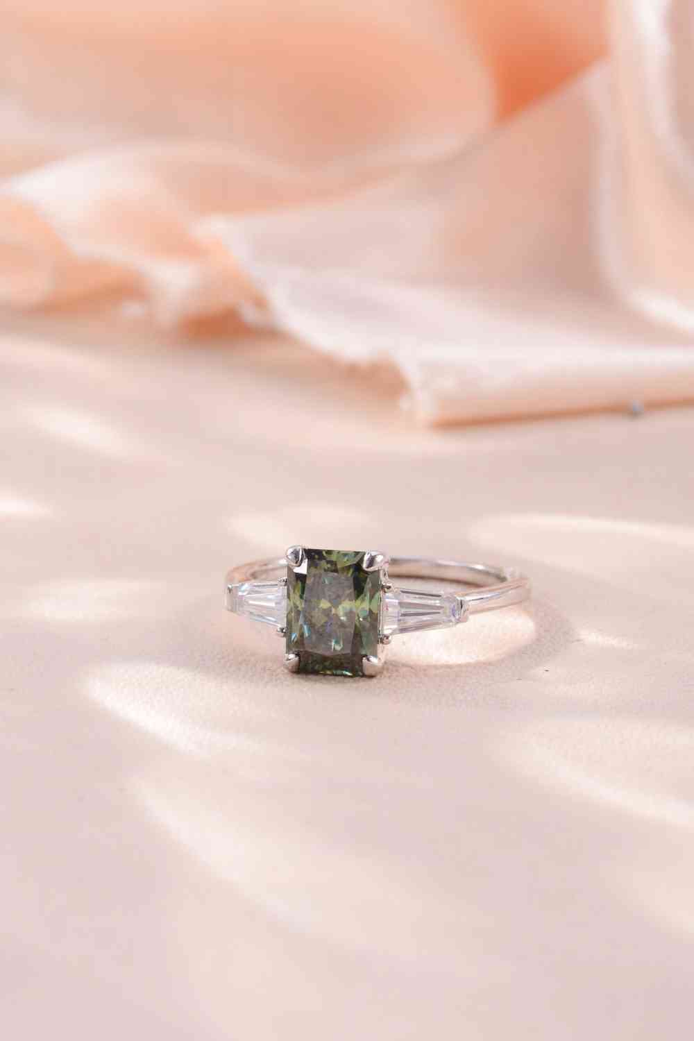 a ring with a green diamond on top of it