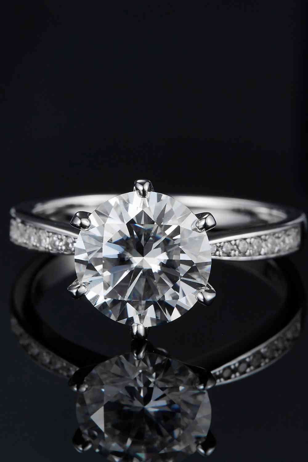 a diamond engagement ring on a black surface