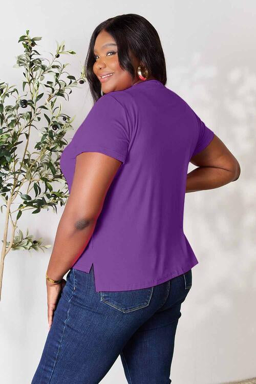 a woman wearing a purple shirt and jeans