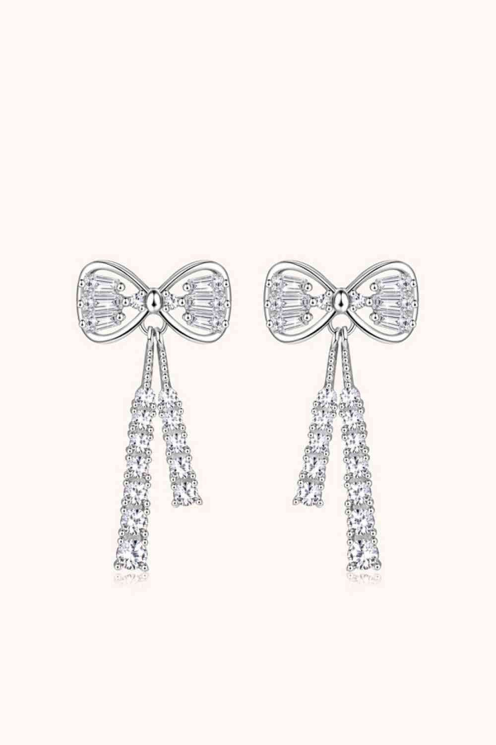 a pair of earrings with bows and diamonds